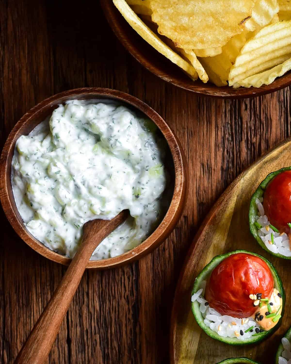 A bowl of an Easy Cucumber Mint Yogurt Dip (Zero Waste Recipe) served with ruffled chips and cucumber cups.