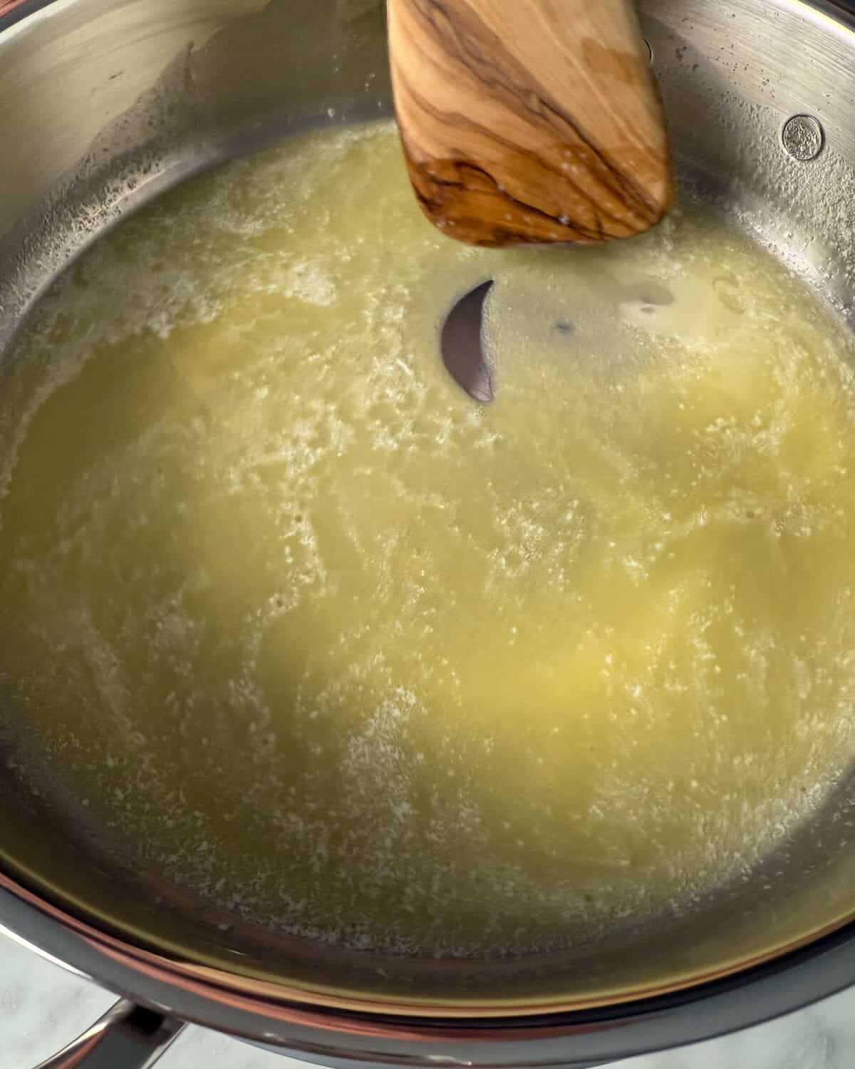 Stirring brown butter in a skillet for a brown butter potato salad.