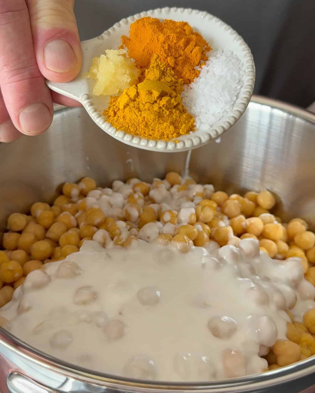 Add spices and coconut milk to the chickpeas to simmer.