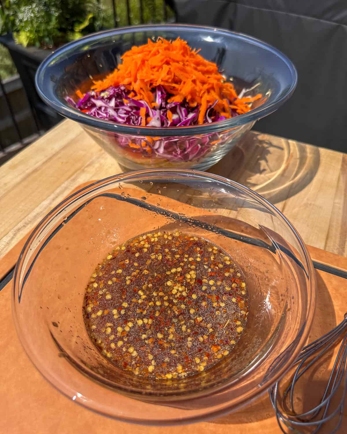 A bowl of asian pickled slaw dressing and a bowl of the slaw.