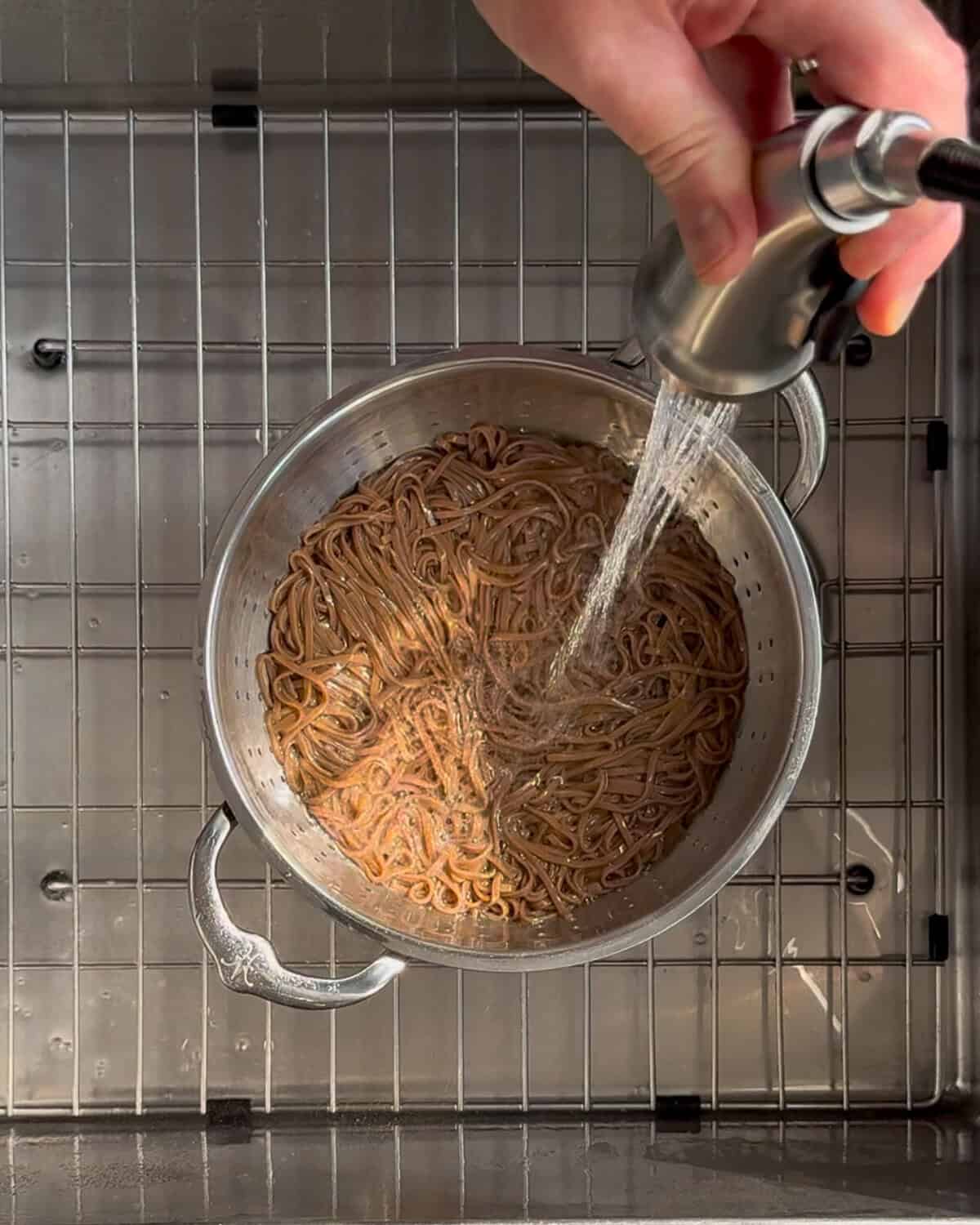 Rinse the soba noodles thoroughly under cold running water, using your hands to agitate the noodles until they are completely cool and no longer sticky.