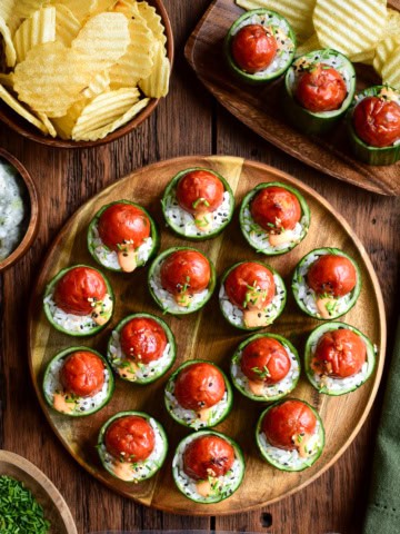A platter of Warm Smokie Popper Sushi Bites in Cucumber Cups. Served with chips and a cucumber dip.