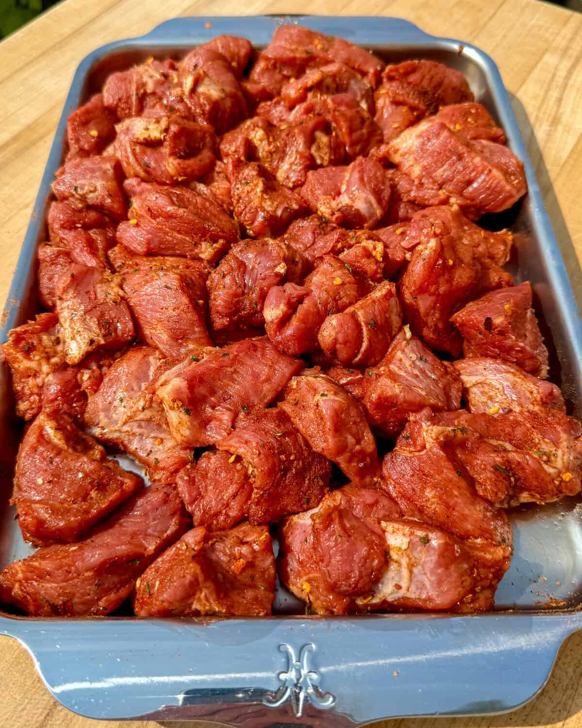 Seasoned jerk pork shoulder cubes on a quarter sheet pan.