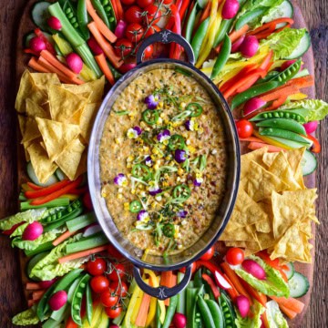 Charred Corn, Poblano and Jalapeño Dip in an oval au gratin. Served with a colourful variety of veggies and tortilla chips.