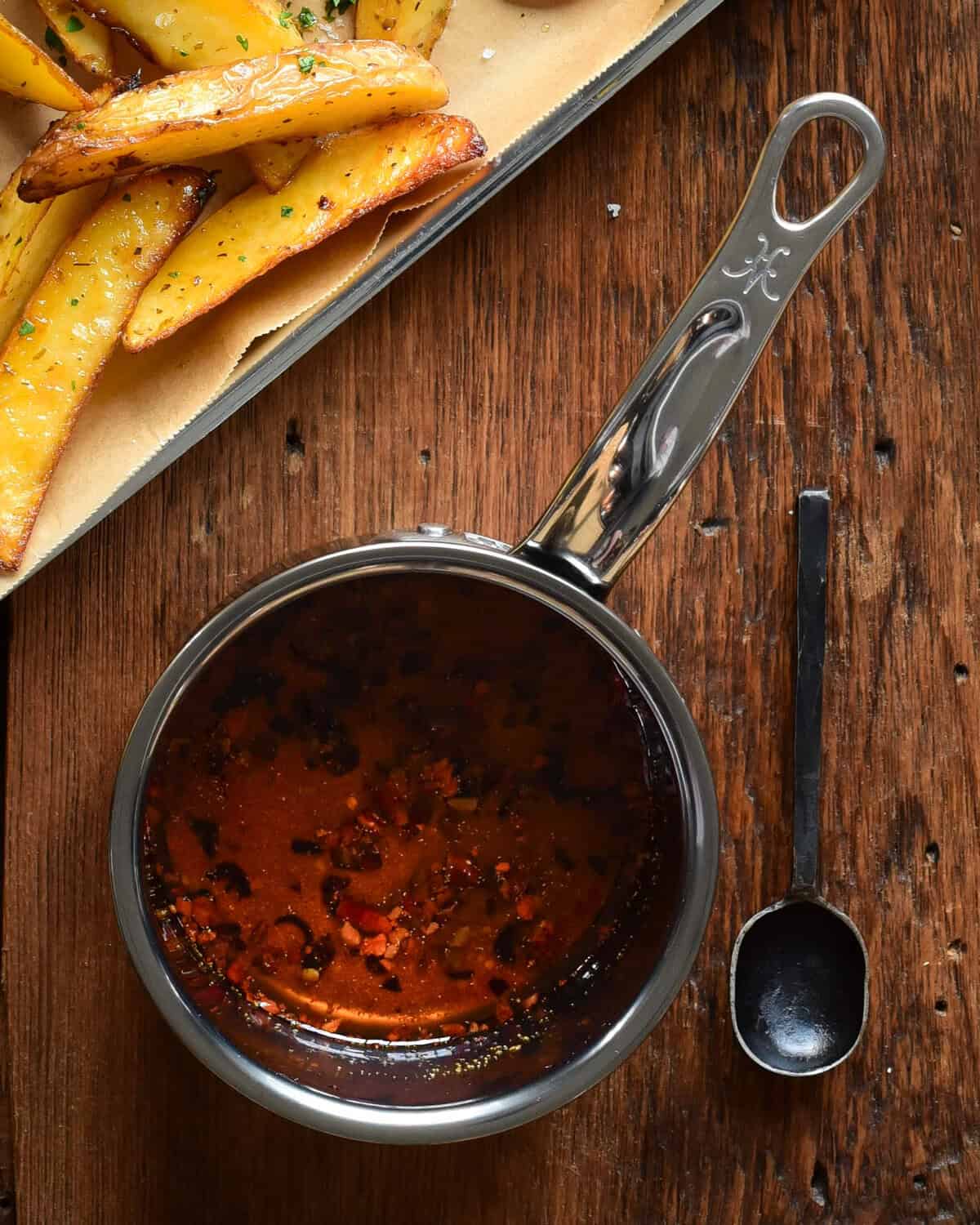 A pot of chili crisp oil with a spoon. 