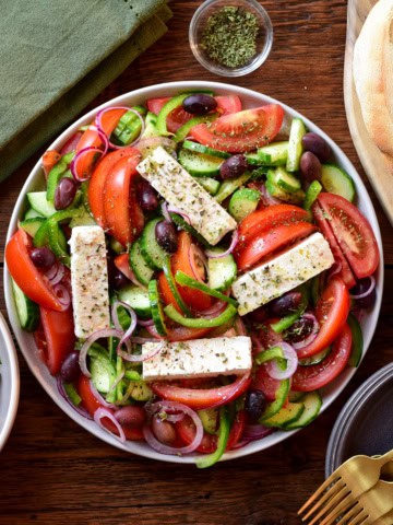 A Greek Village Salad (Horiatiki Salata) with four pieces of feta on top.