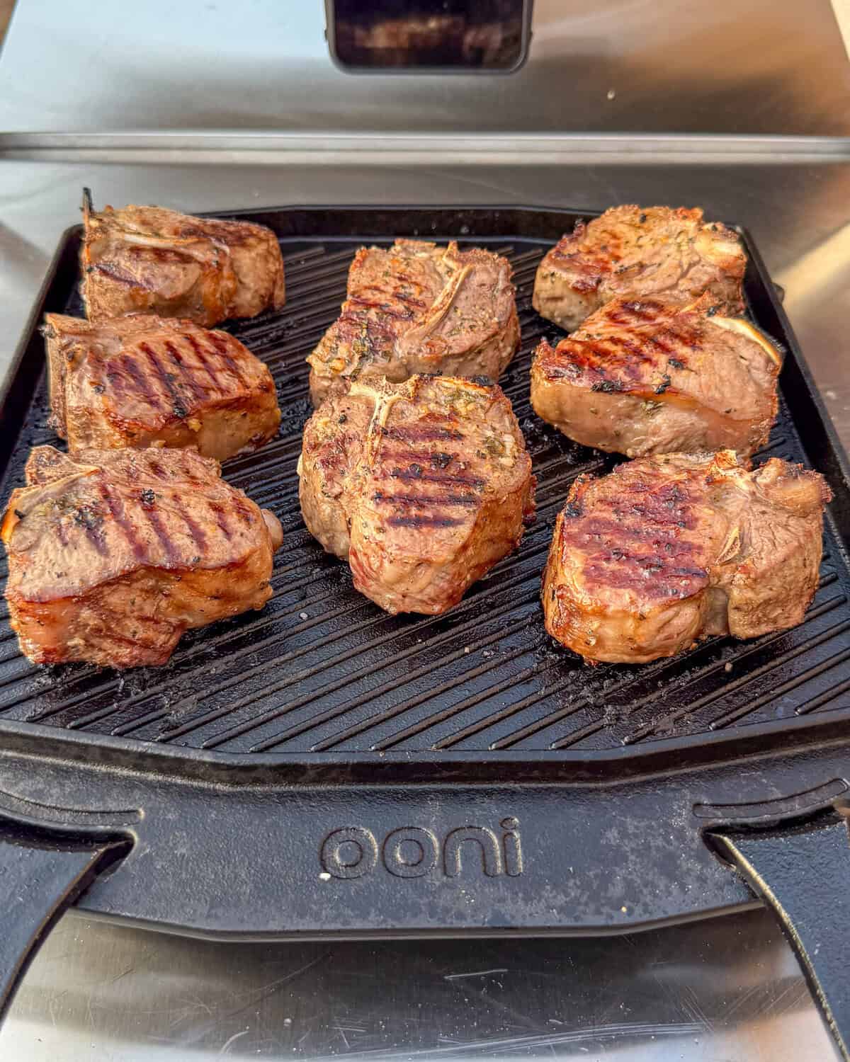Grilled baby lamb chops on a cast-iron griddle.