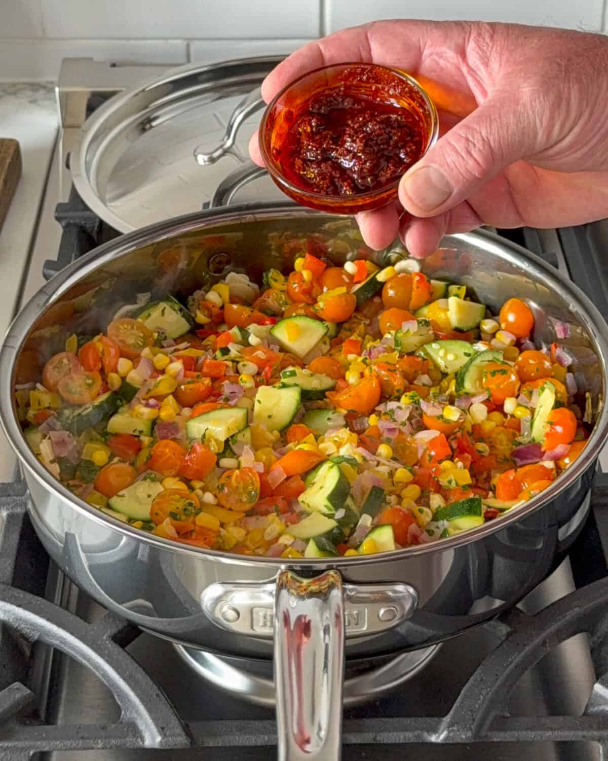 Stir in the herbs and harissa into the vegetable shakshuka. 