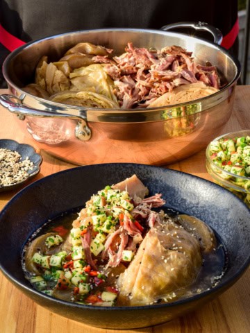 A copper pot filled with cider-braised cabbage and ham, served in a bowl with an apple gremolata.