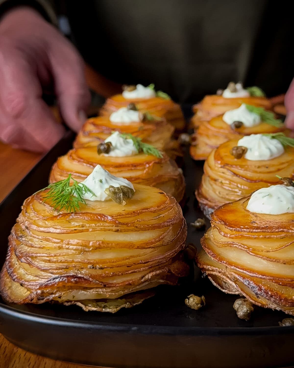 A close-up of Lemon–Dill Potato Stacks with Greek Yogurt & Capers.