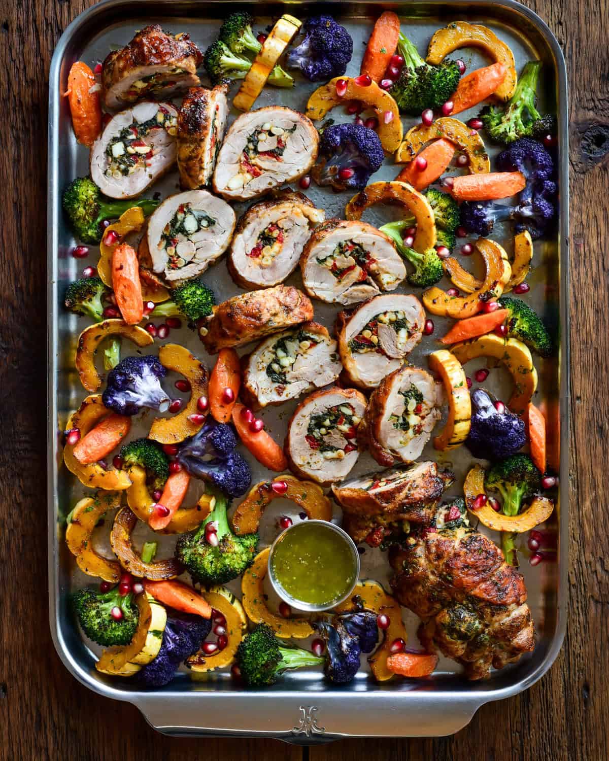 A sheet pan with slices of a stuffed and rolled turkey thighs
