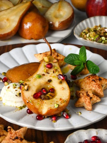 Honey roasted pear halves served with marscarpone, pistachios, puff pastry stars, mint and pomegranate arils.