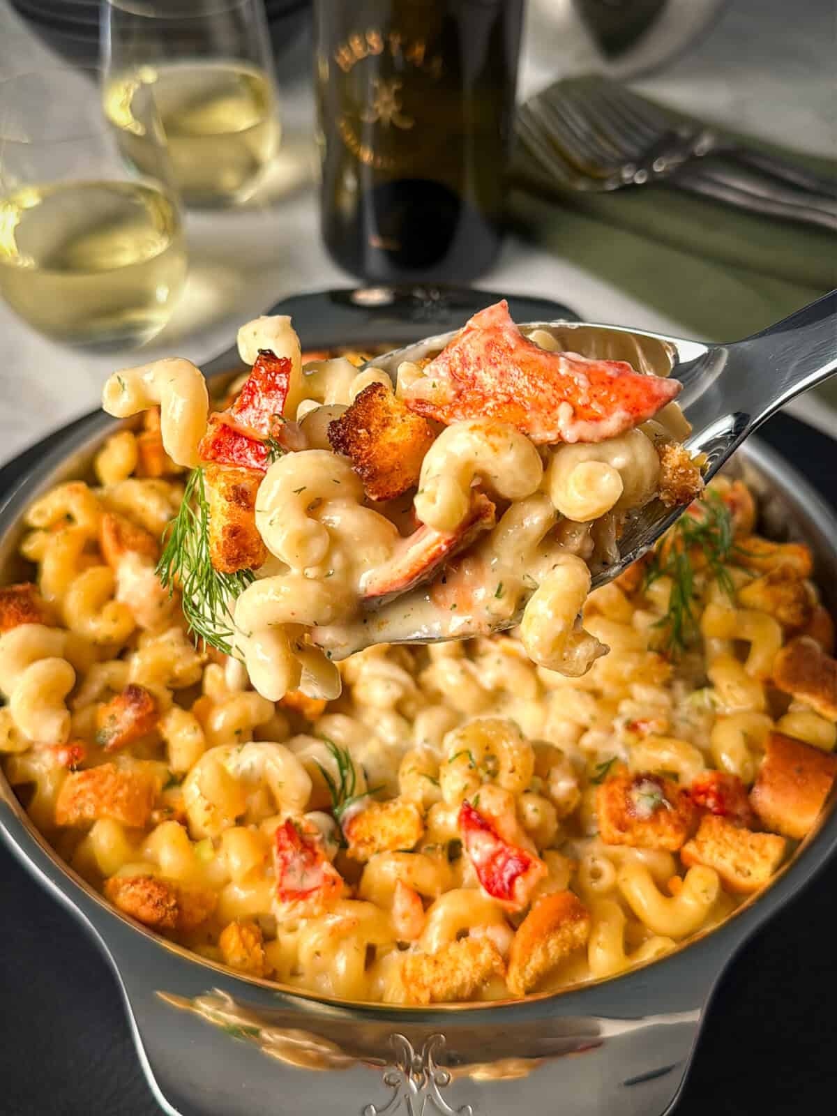 Lifting a scoop of a lobster style mac and cheese.