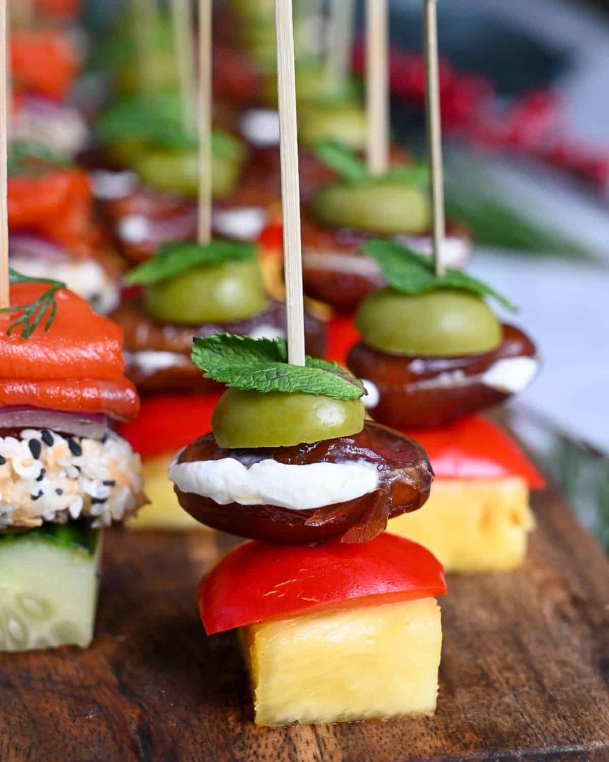 A close up of a Labneh, Pineapple, Pickled Cherry Pepper and Date Skewers 