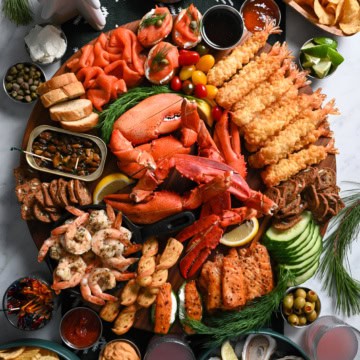 A SeaCuterie Board (Seafood Charcuterie Board) with a variety of seafood, sauces, crackers and dips.
