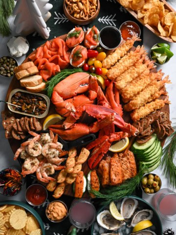 A SeaCuterie Board (Seafood Charcuterie Board) with a variety of seafood, sauces, crackers and dips.