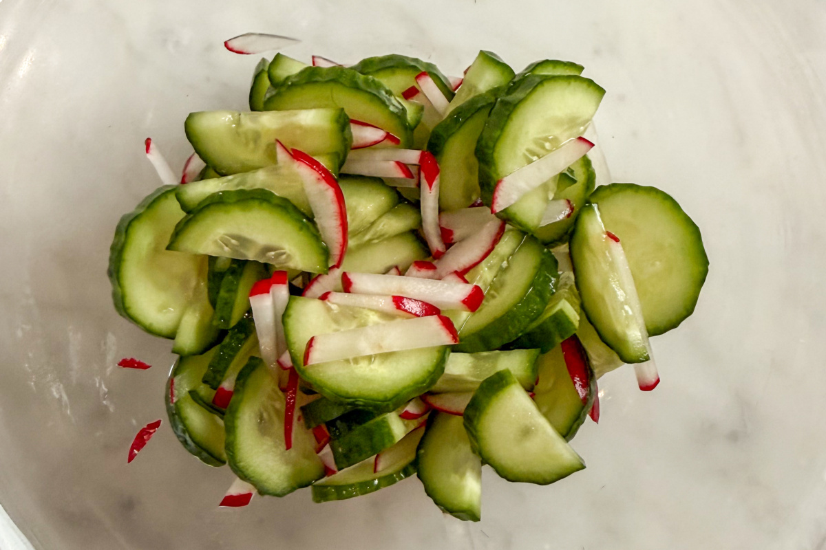 A bowl of quick-pickled cucumbers and radishes.