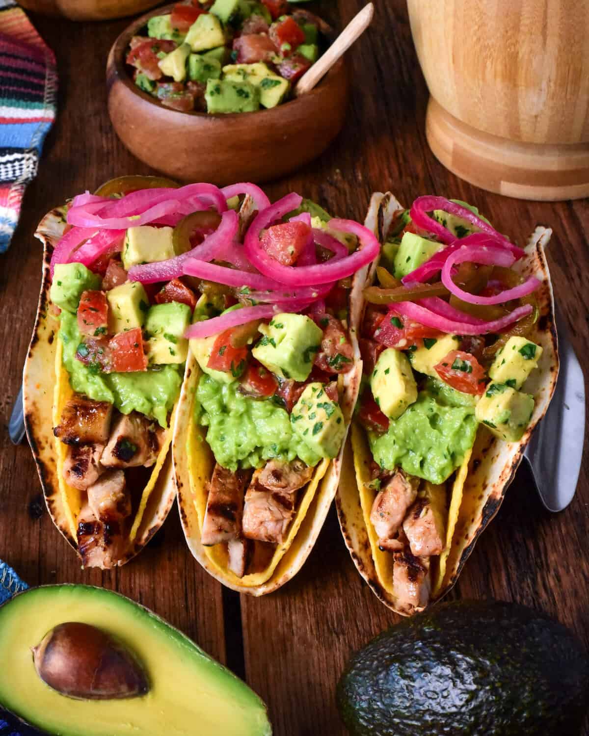 Three citrus marinated grilled pork double decker tacos in a stand.