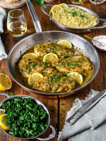 A skillet of lemony chicken picatta is served with orzo and spinach.