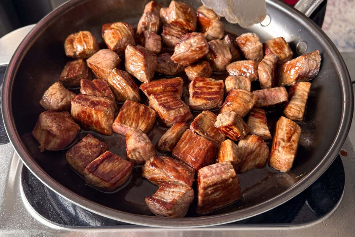 A deglazed pan with the beef cubes back in the pan.