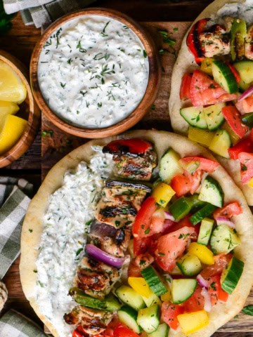 A bowl of creamy whipped feta tzatziki served with a chicken souvlaki pita.