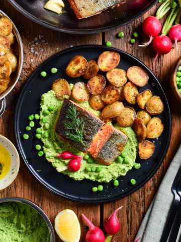 A dish served with Crispy Skin Salmon with Minty Pea Purée & Roasted Potatoes.