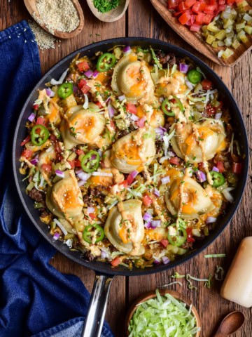 A cheeseburger skillet with pierogi, served with extra toppings on the side.