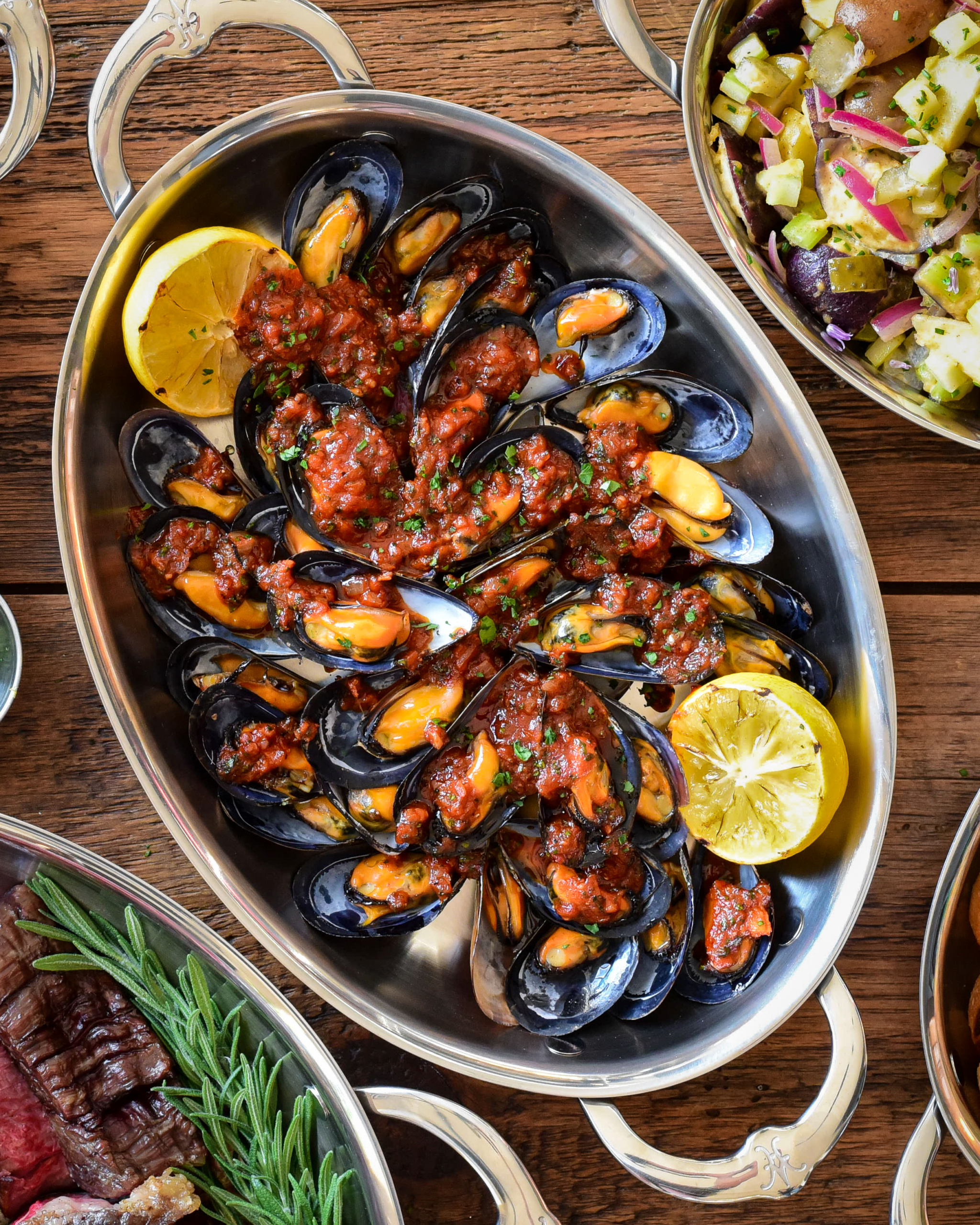 Mejillones en Salsa Picante Spanish Mussels on Half Shell served in an oval au gratin with grilled lemon wedges.